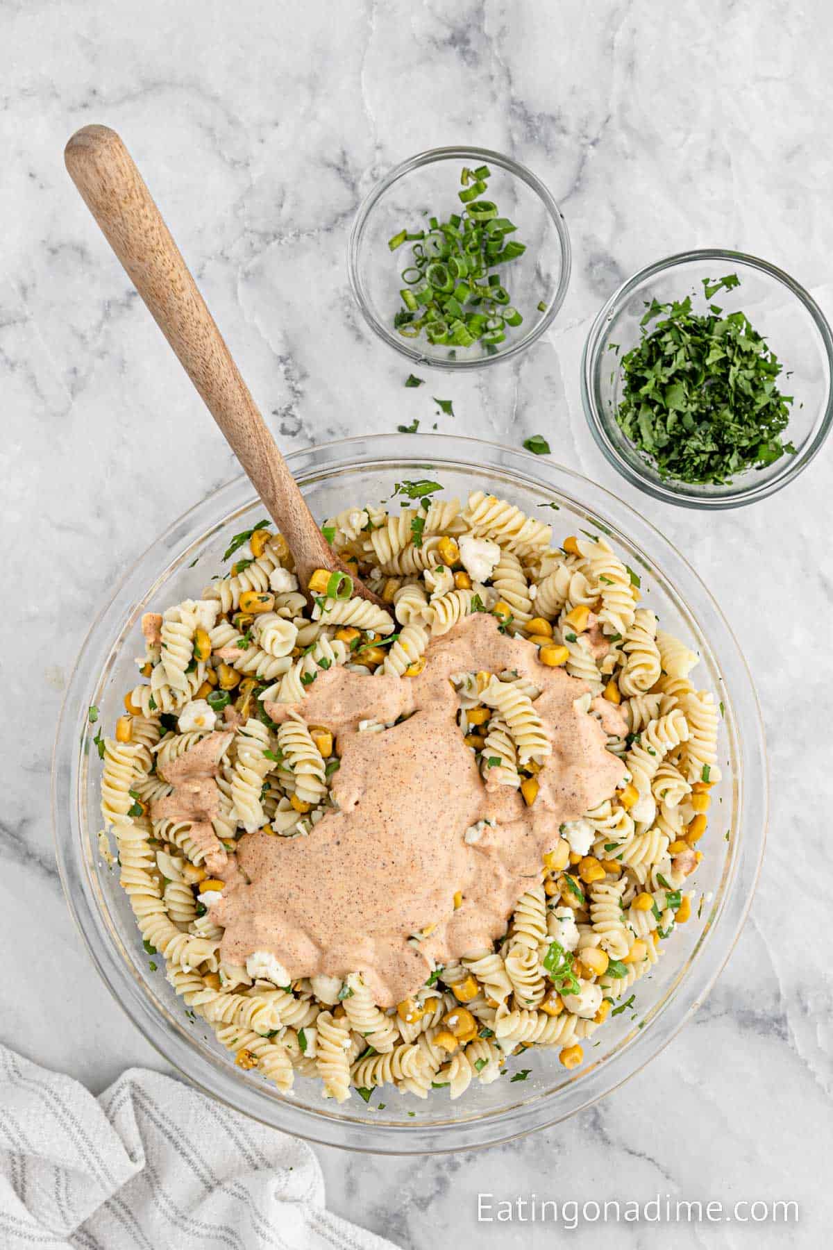 Topping the dressing over the pasta ingredients