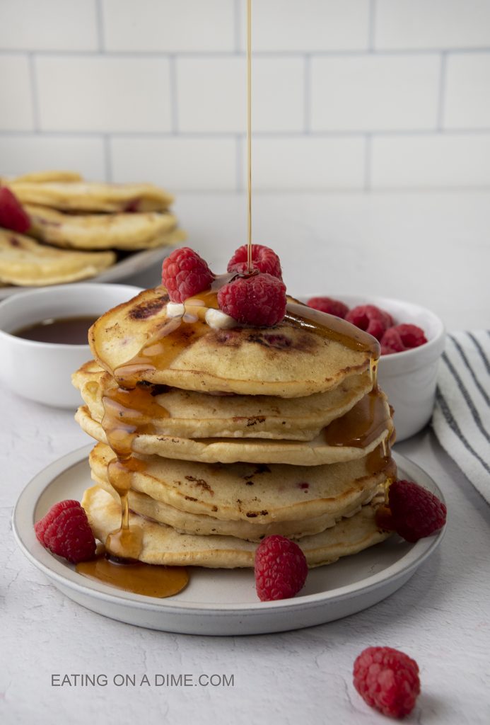 Raspberry pancakes stacked on a plate. 