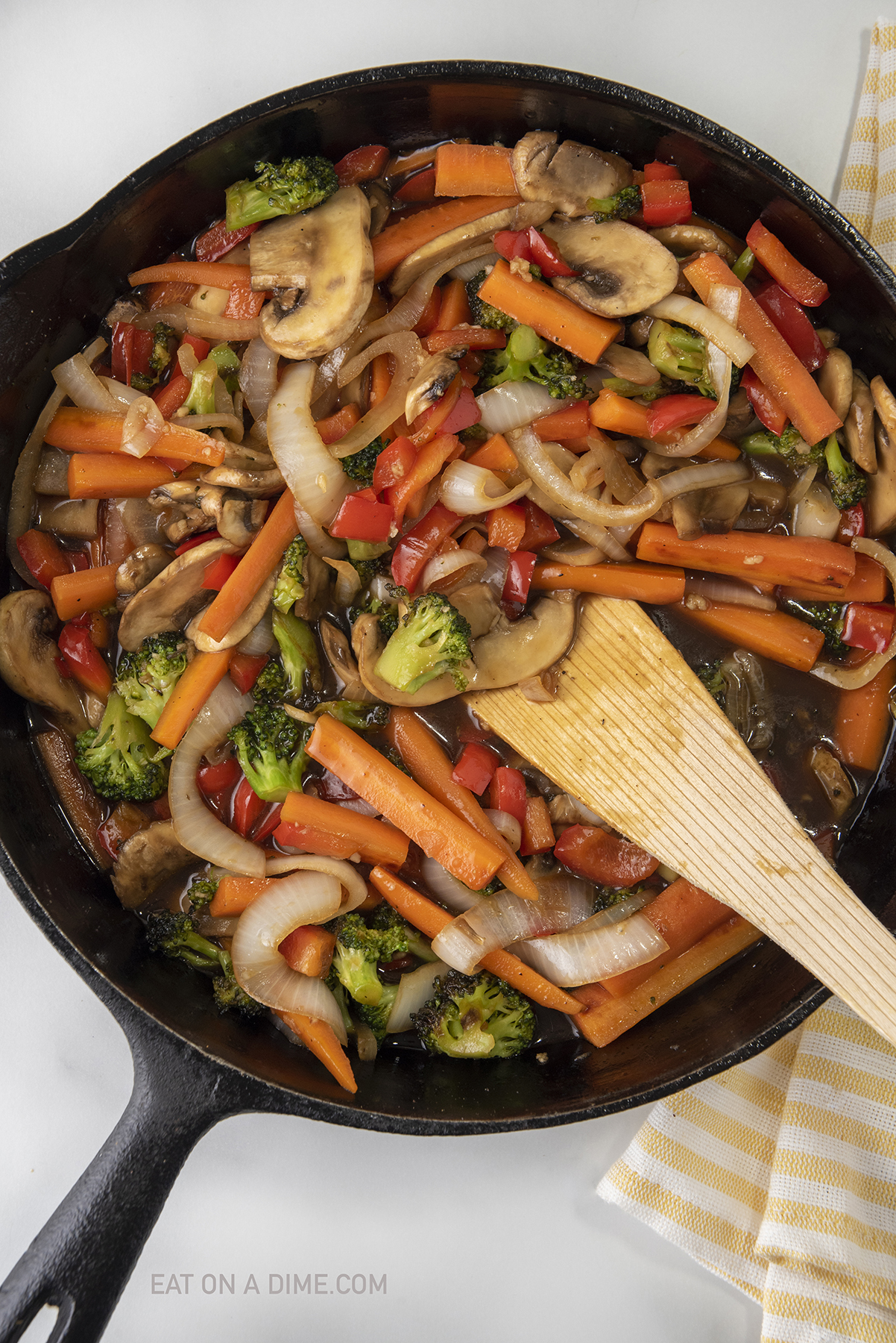 Teriyaki Vegetables in a skillet with a wooden spoon
