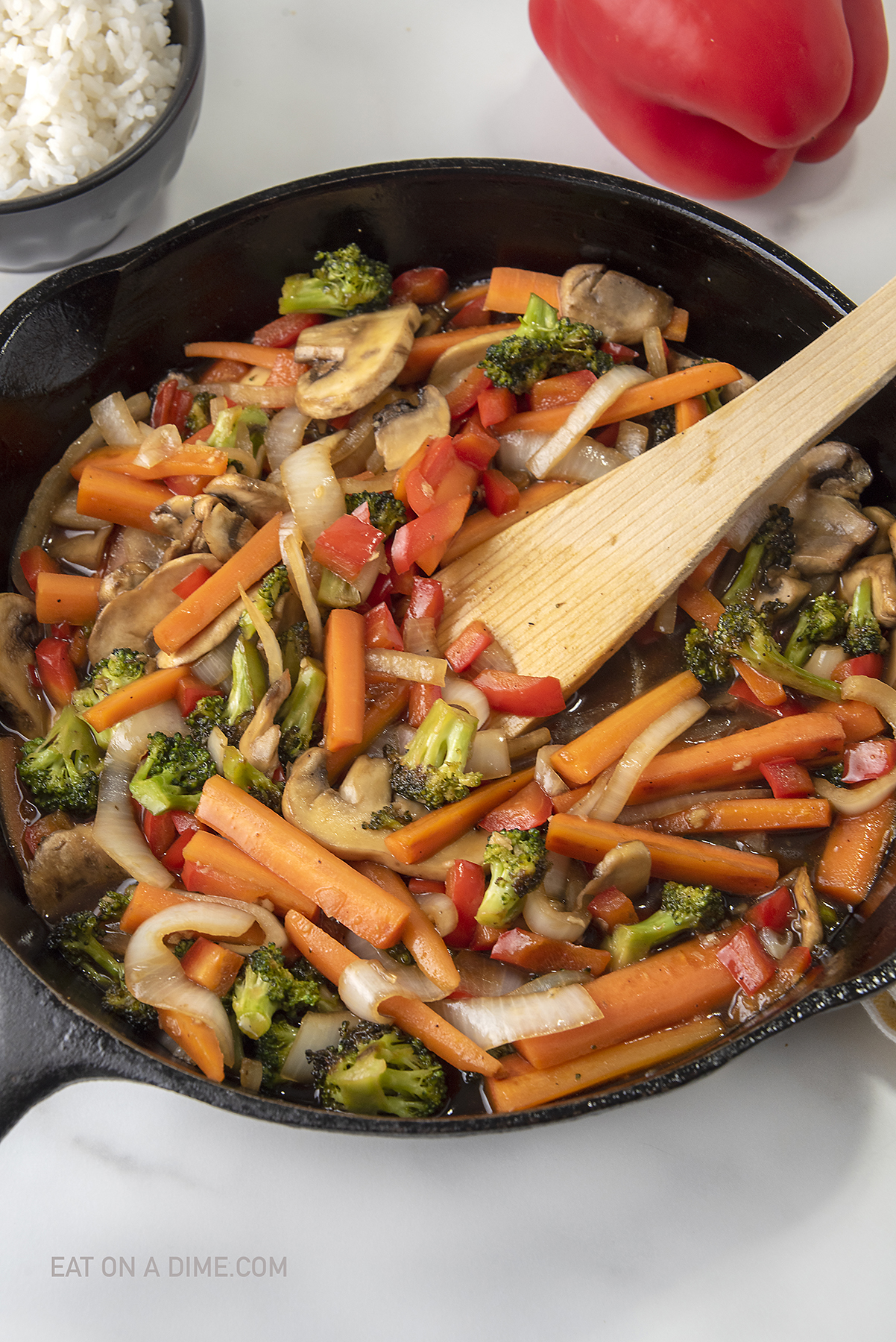 Teriyaki Vegetables in a skillet with a wooden spoon