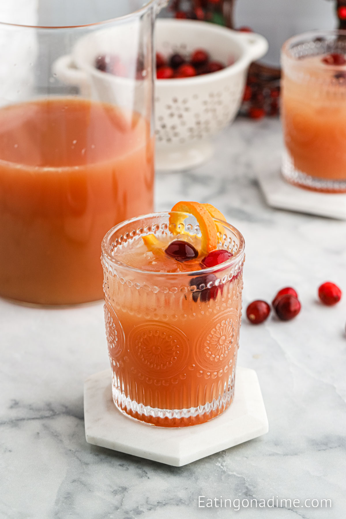 Christmas Morning Punch in a glass garnished with orange slices and cranberries