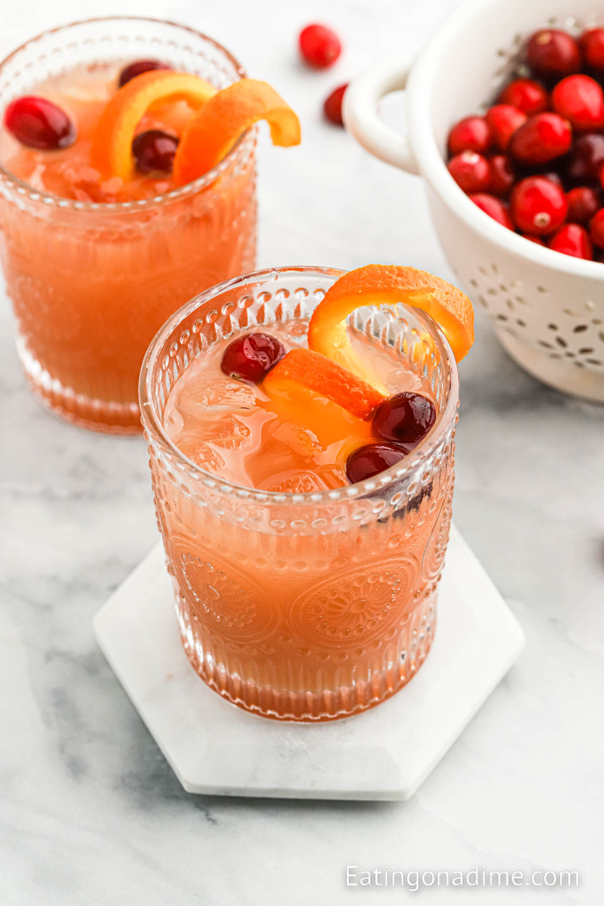 Christmas Morning Punch in a glass garnished with orange slices and cranberries