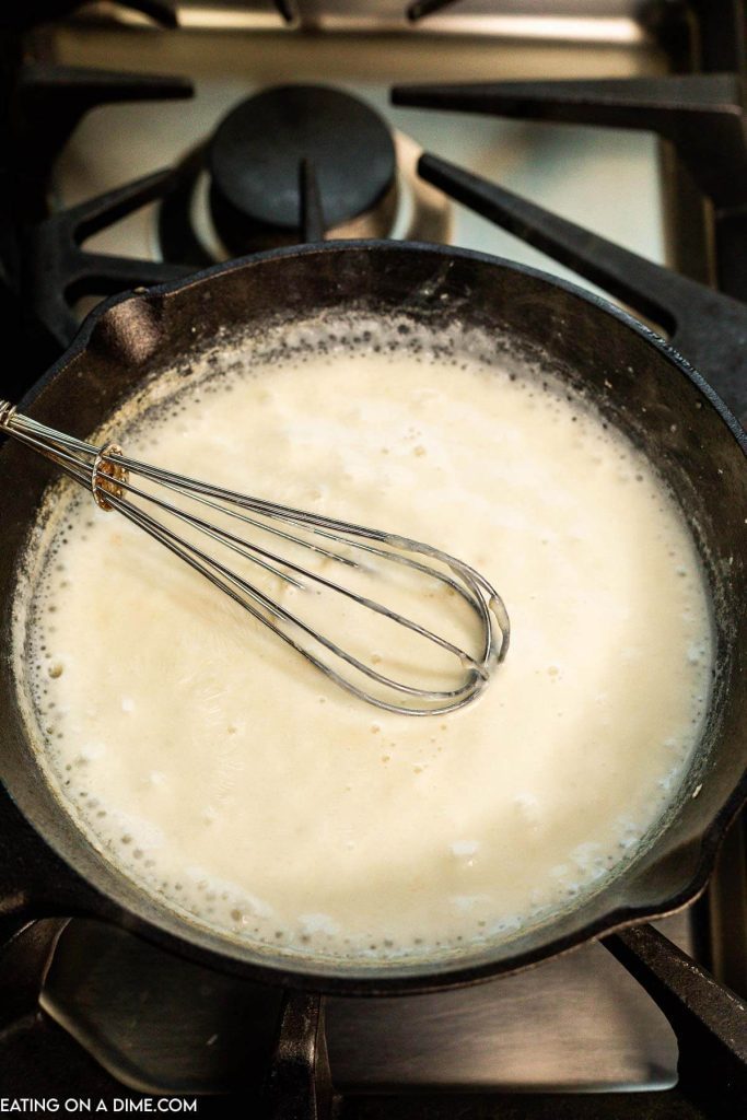 Whisking the cheese in a cast iron skillet