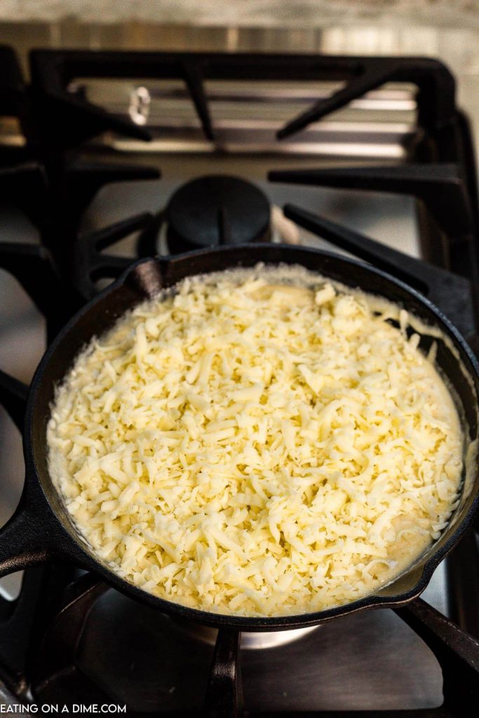 Adding the shredded cheese in the skillet