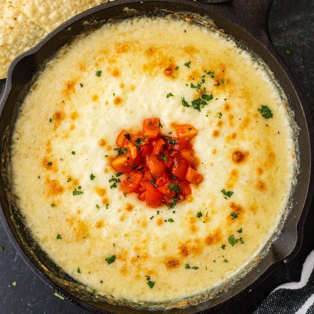 Queso Fundido in a skillet with a side of tortilla chips