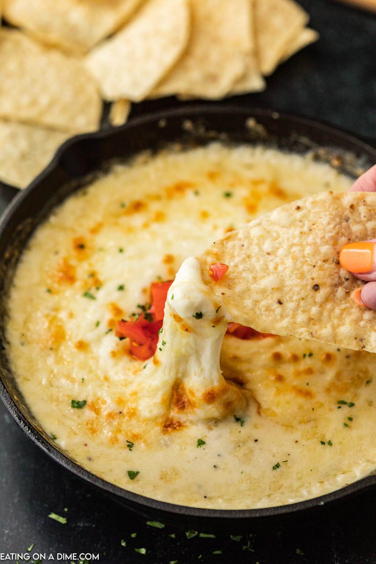 Queso Fundido in a skillet with a side of tortilla chips