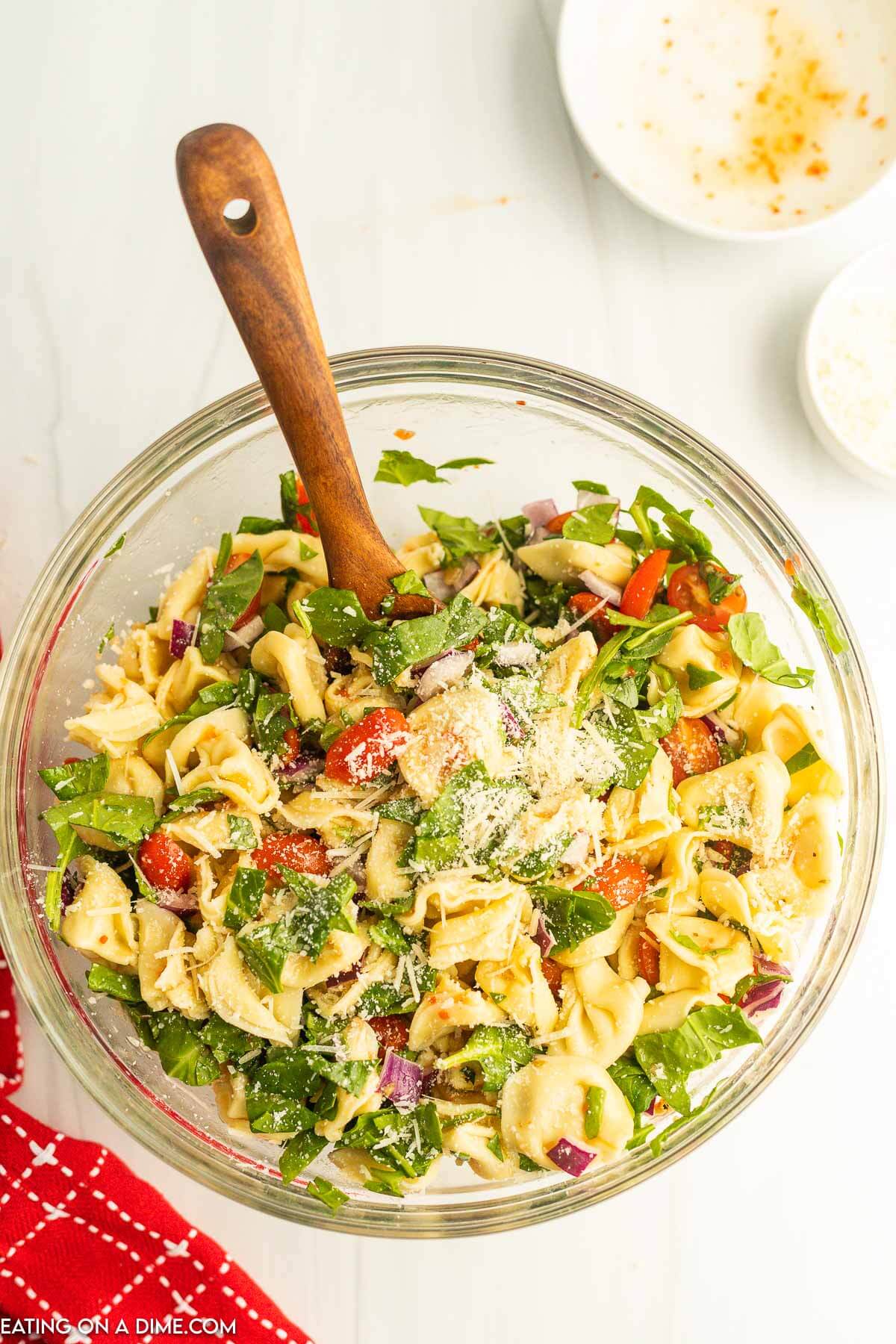 Topping the salad with shredded parmesan cheese