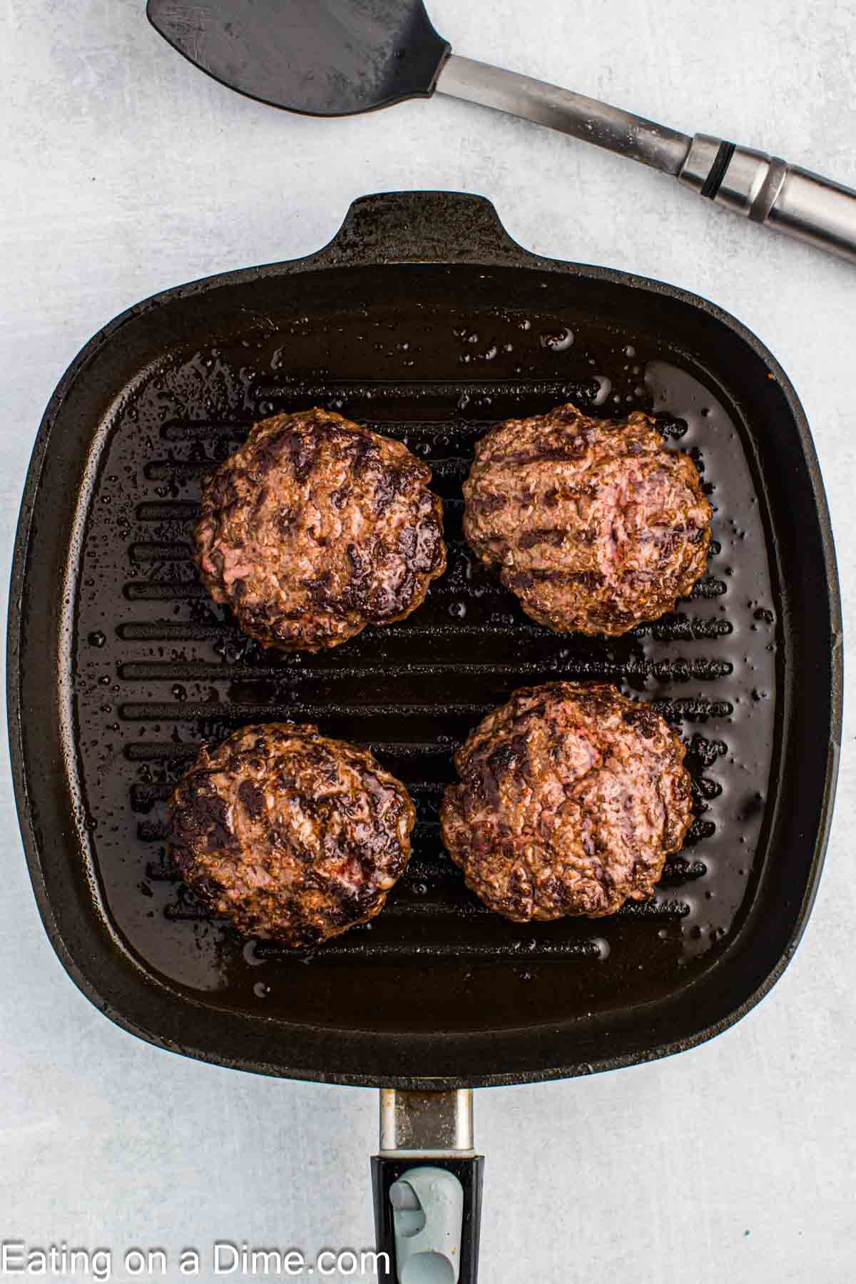 Cooked hamburger patties in a skillet