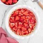 A strawberry pie with a white crust and strawberries.