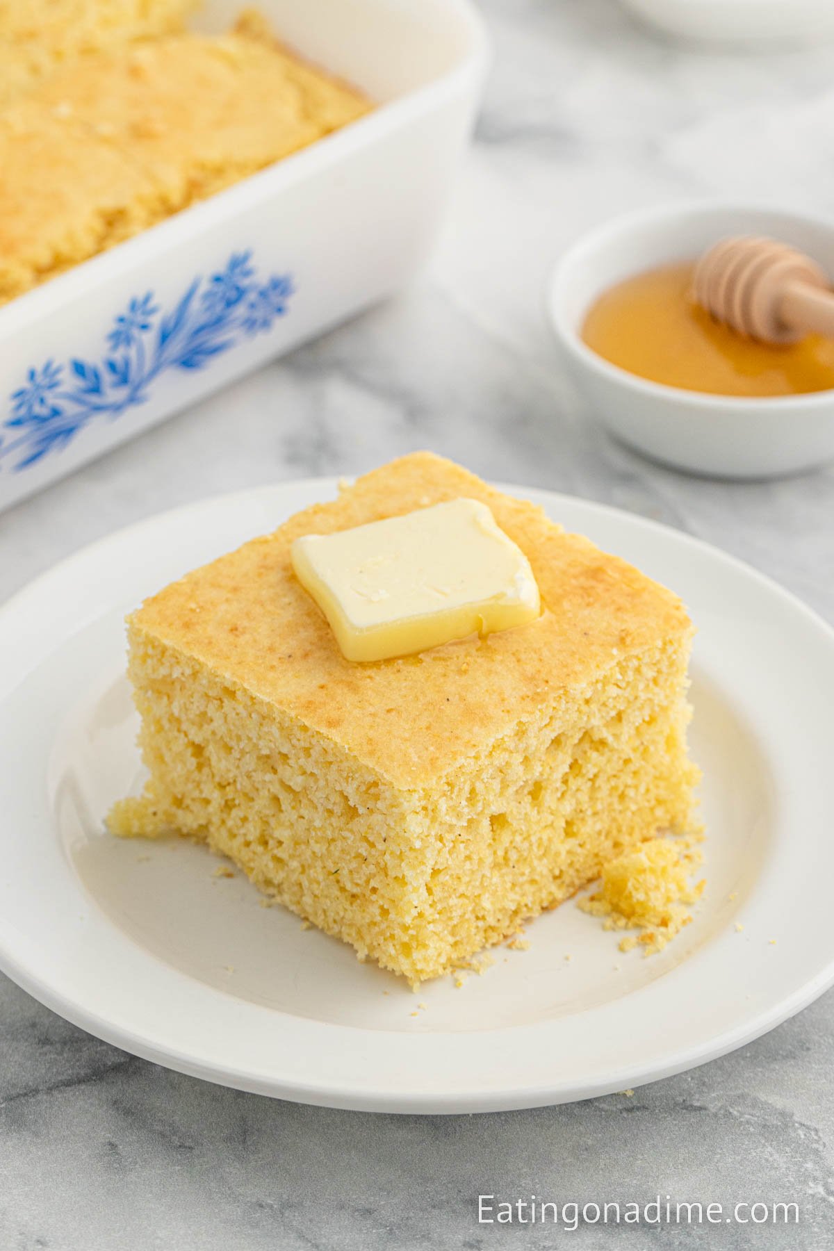 Slice of cornbread on a plate topped with butter