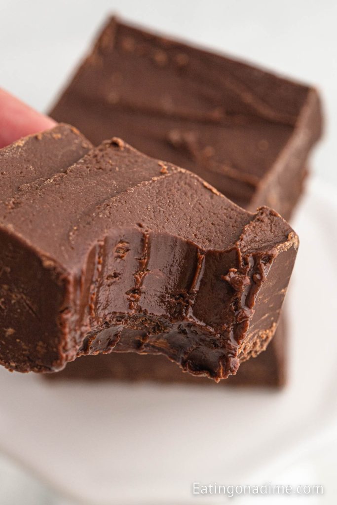 Chocolate fudge cut into squares and one is close up