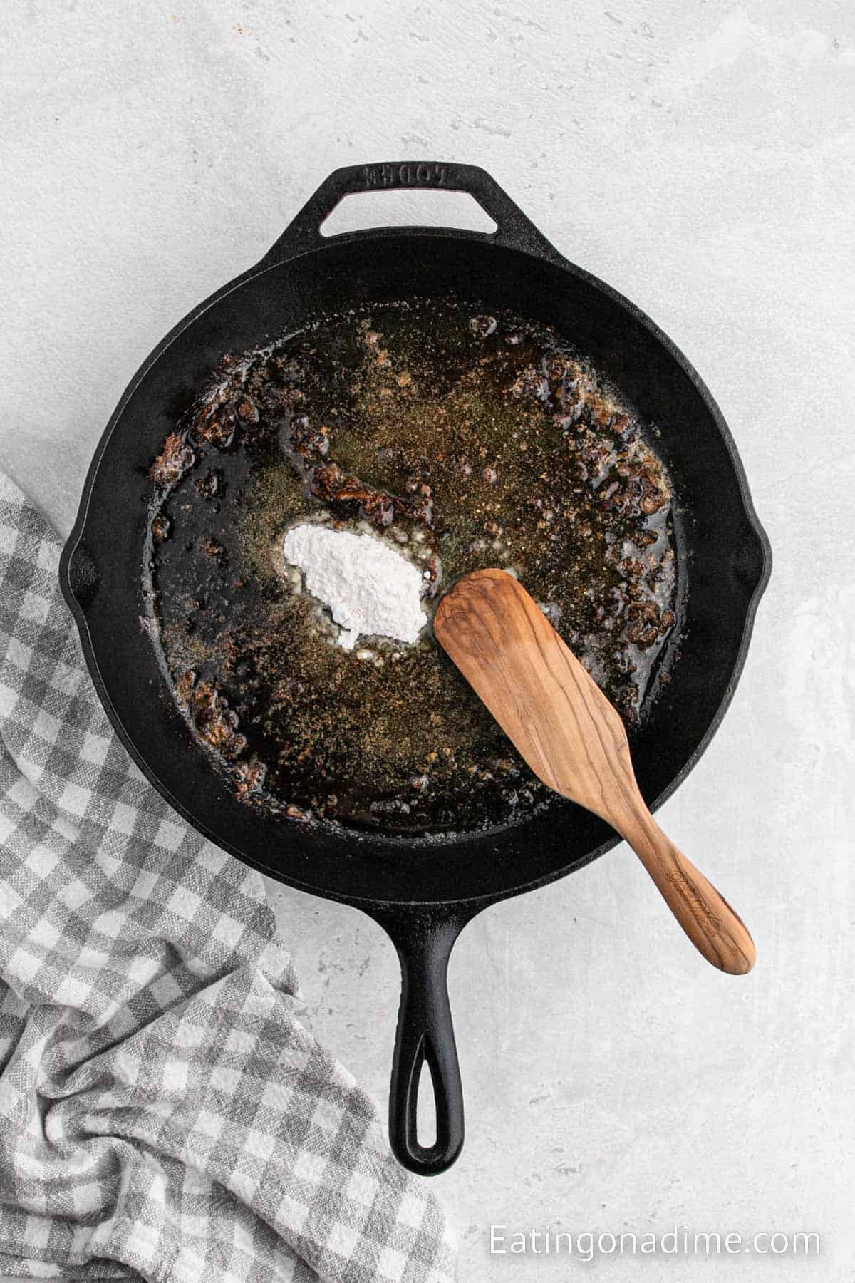 Adding flour to the skillet with the melted butter