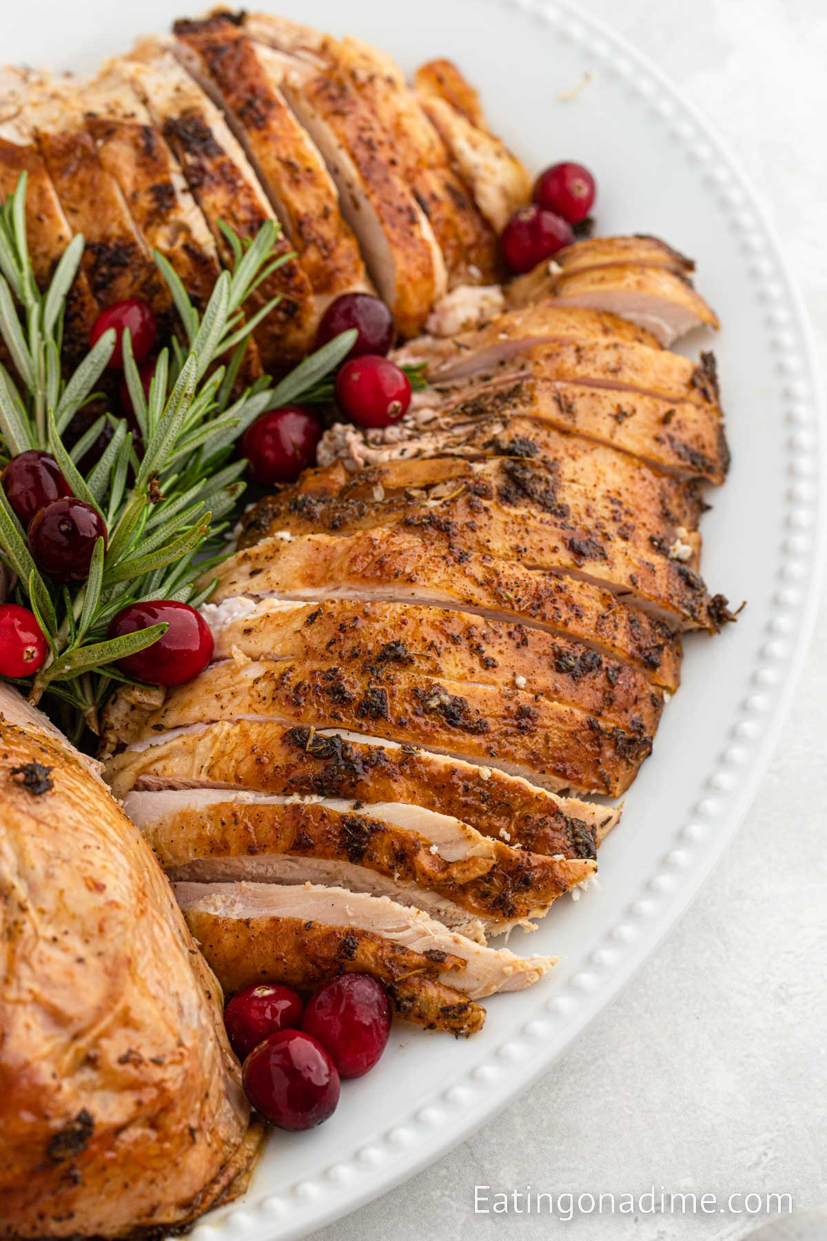 Grilled Turkey on a platter with fresh herbs and berries