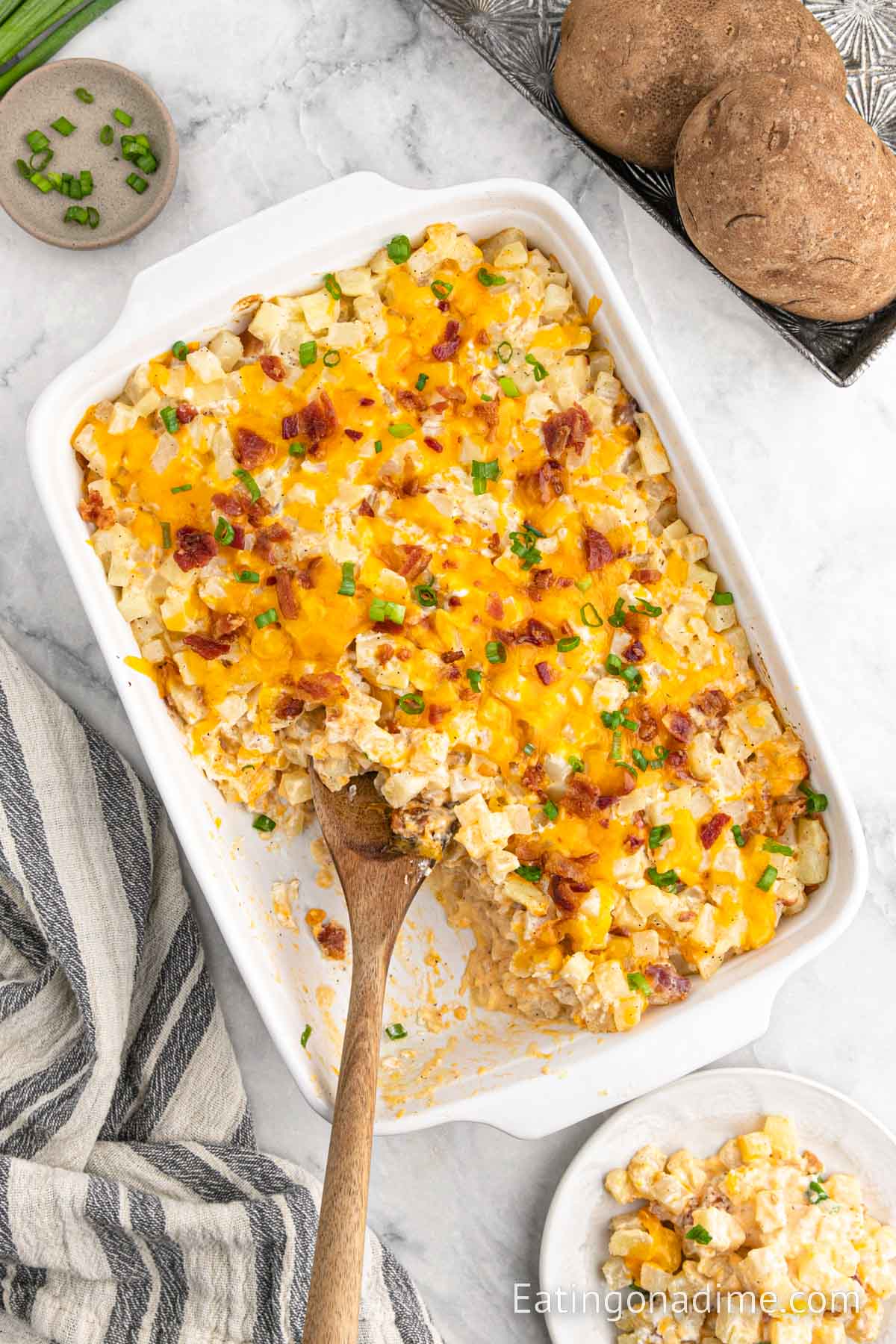 Loaded baked potato casserole with a wooden spoon