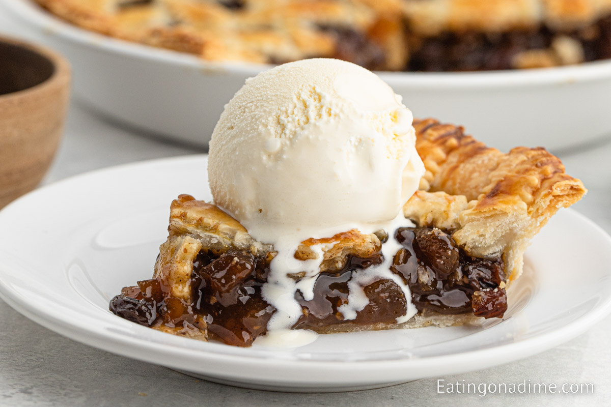 Mincemeat pie with a serving on a plate with a scoop of ice cream