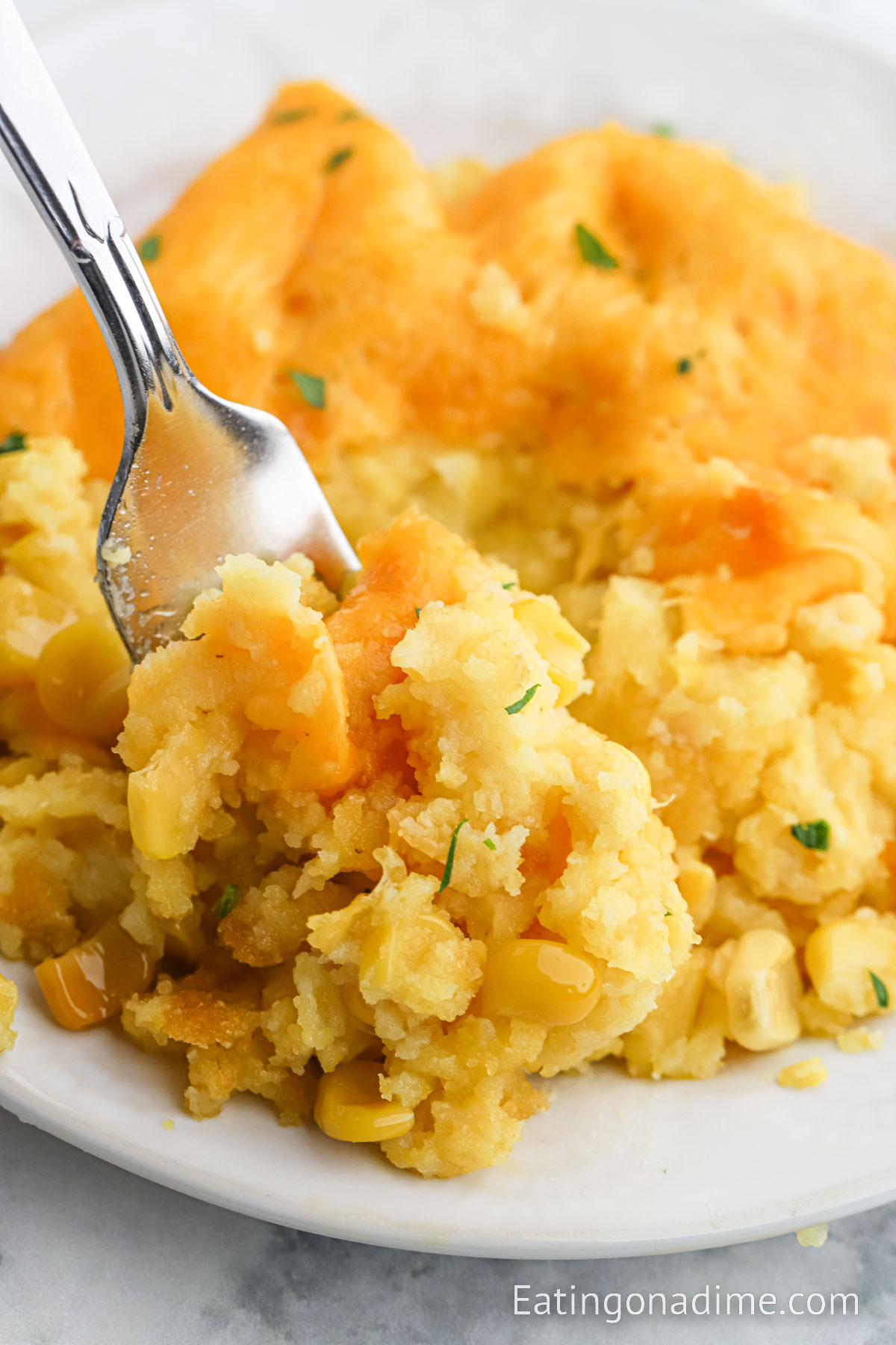 Corn casserole on a plate with fork