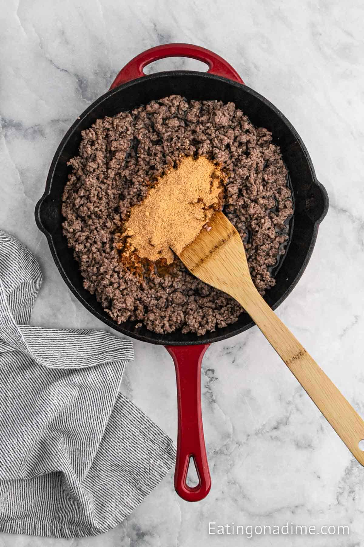 Mixing in the taco seasoning into the ground beef in the skillet