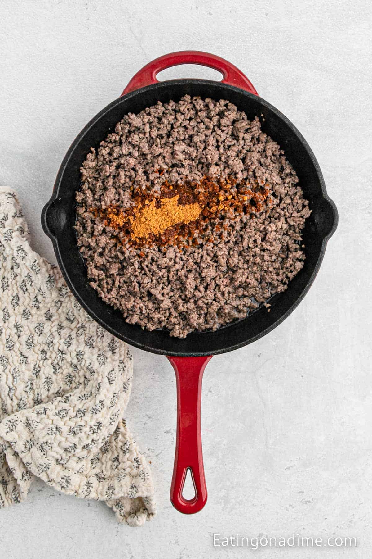 Ground beef in a skillet topped with seasoning