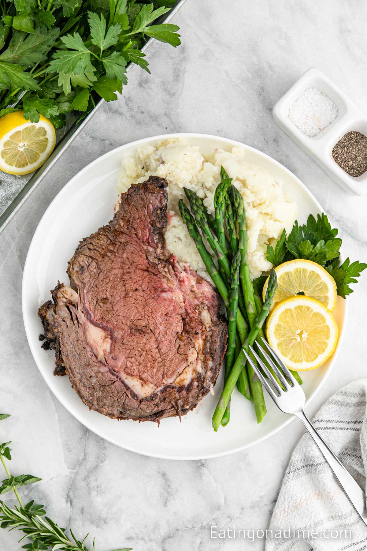 Prime Rib on a plate with asparagus and mashed potatoes