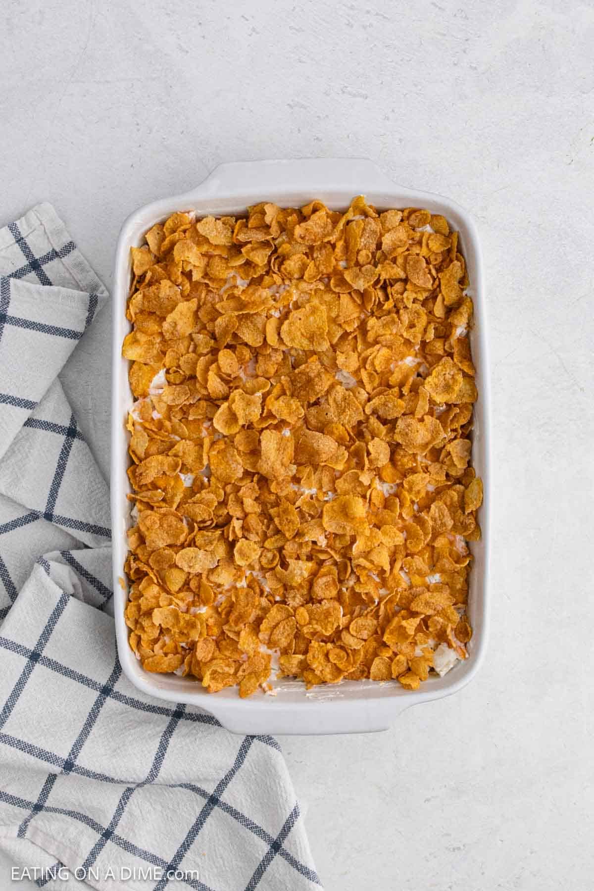 Hashbrown mixture added to the baking dish and topped with corn flakes.