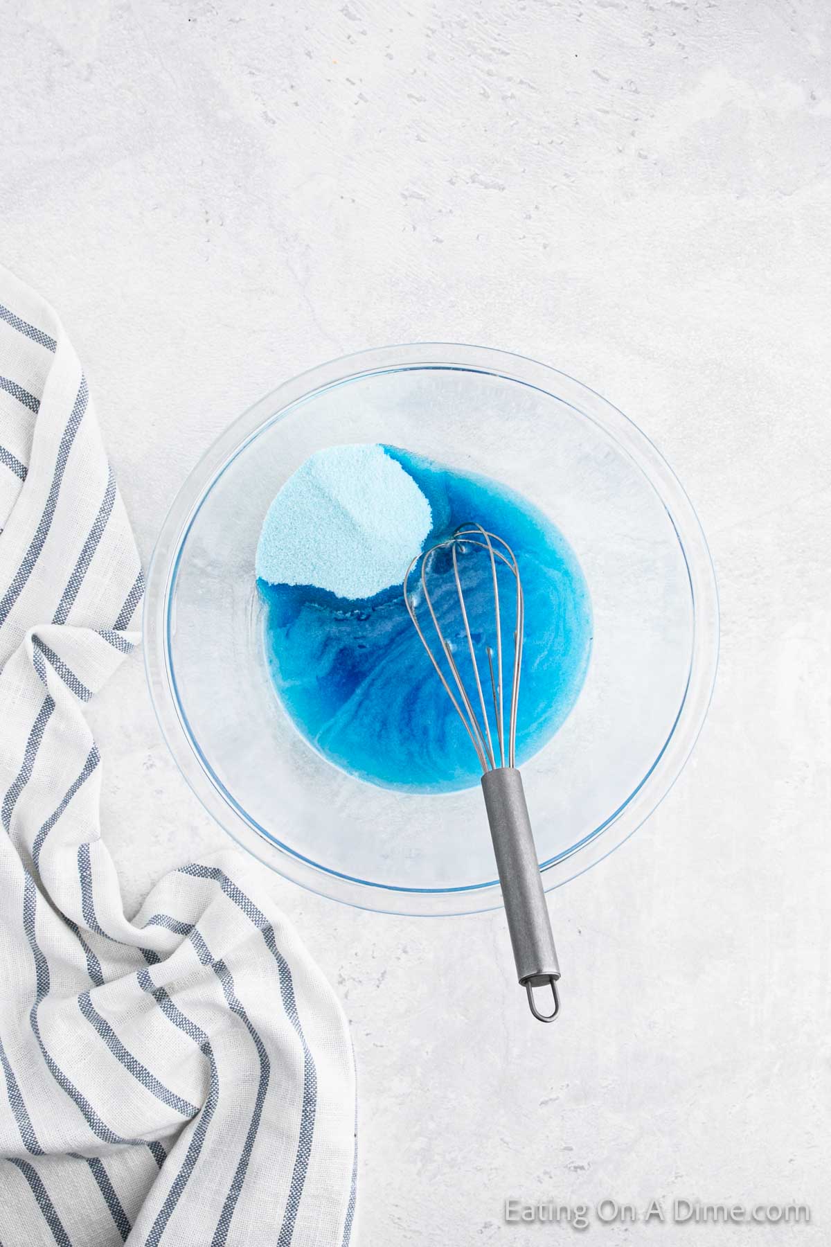 Mixing water and blue jello in a bowl