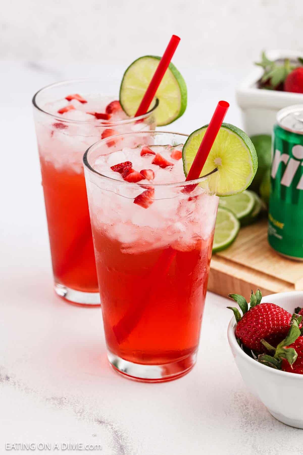 Strawberry drink topped with diced strawberries and a lime wedge on the rim.