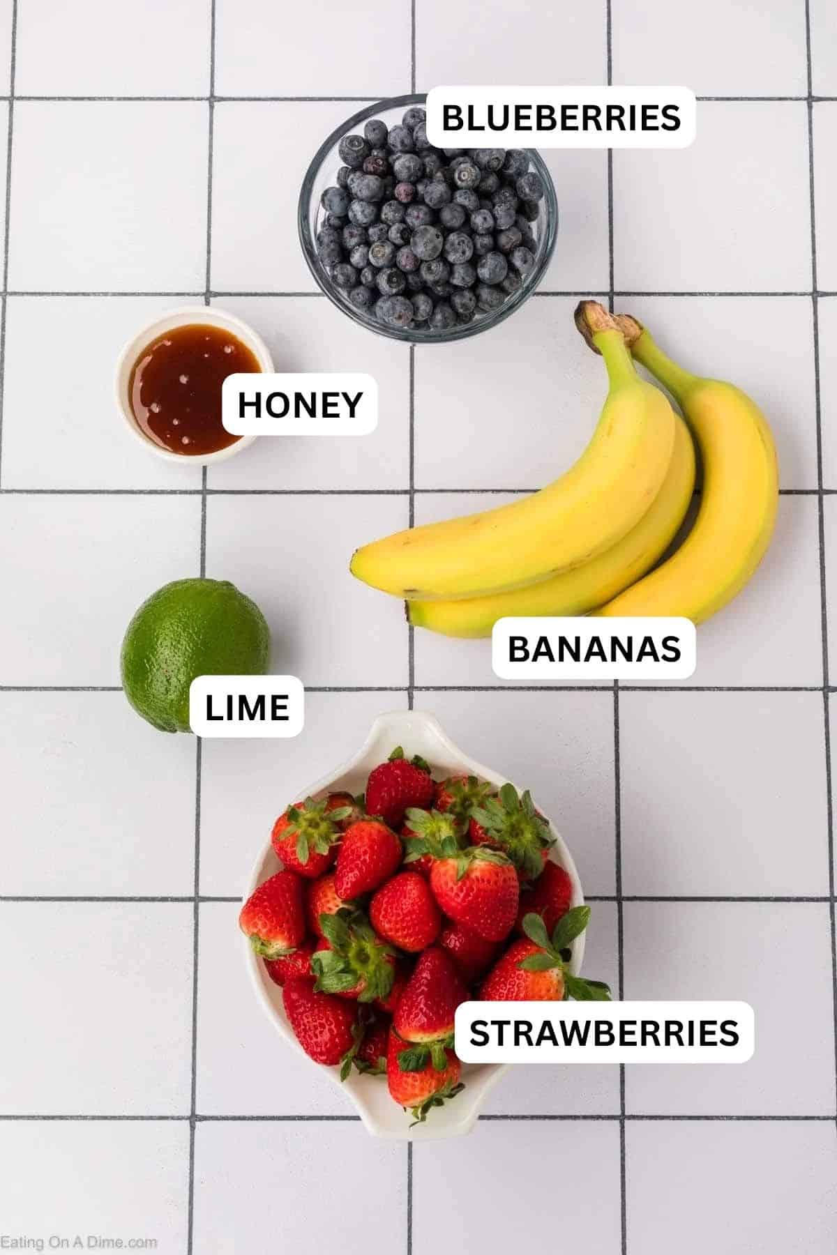 Ingredients needed to make this recipe which includes Blueberries, Strawberries, bananas, lime, and honey.