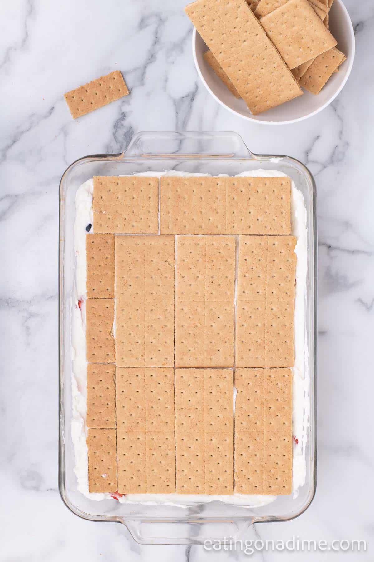 Graham crackers topped the on the cream layer in the baking dish