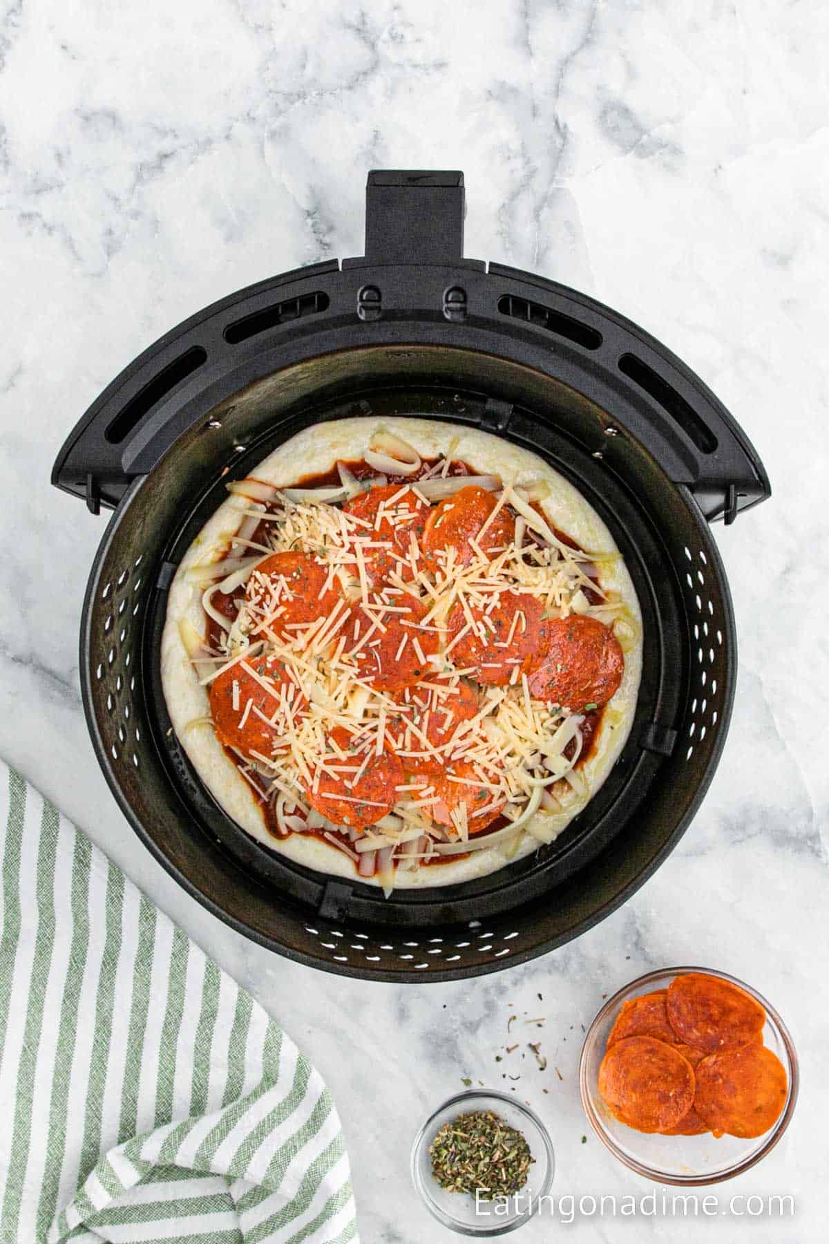 Top the pizza sauce with the shredded cheese and pepperoni