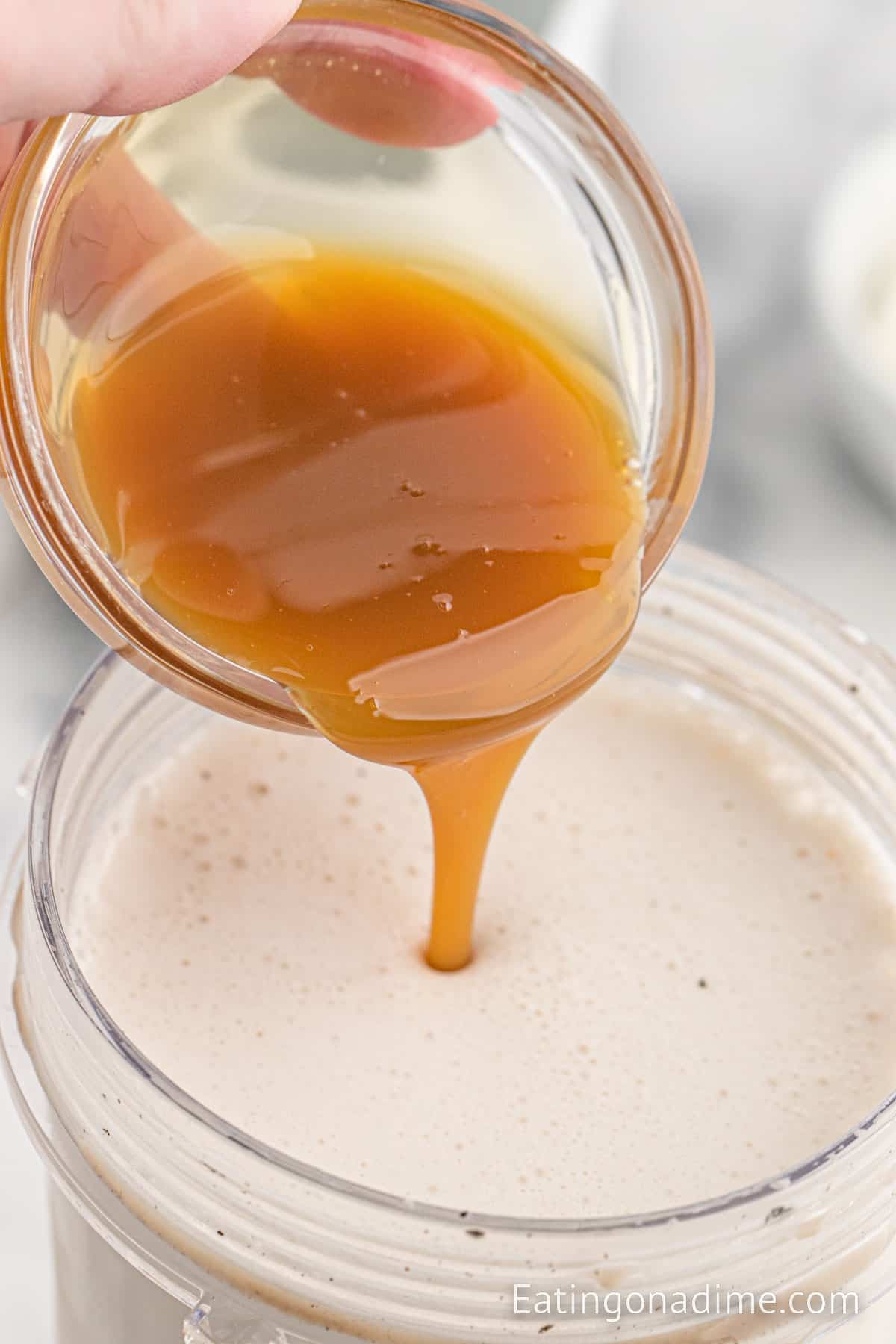 Pouring caramel sauce in the blended coffee mixture