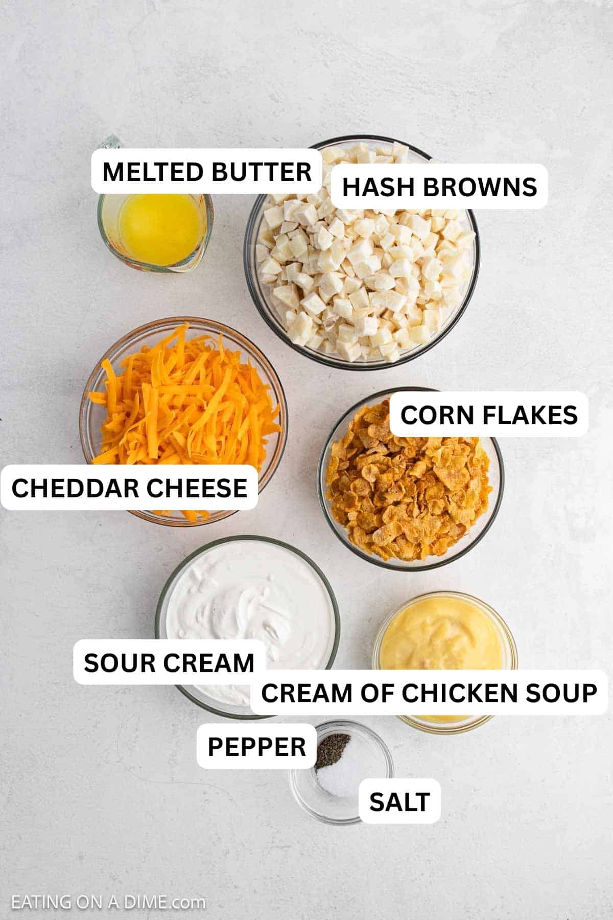 Ingredients needed for this recipe includes diced hash browns, sour cream, cream of chicken soup, butter, cheddar cheese, salt, pepper, and corn flakes.