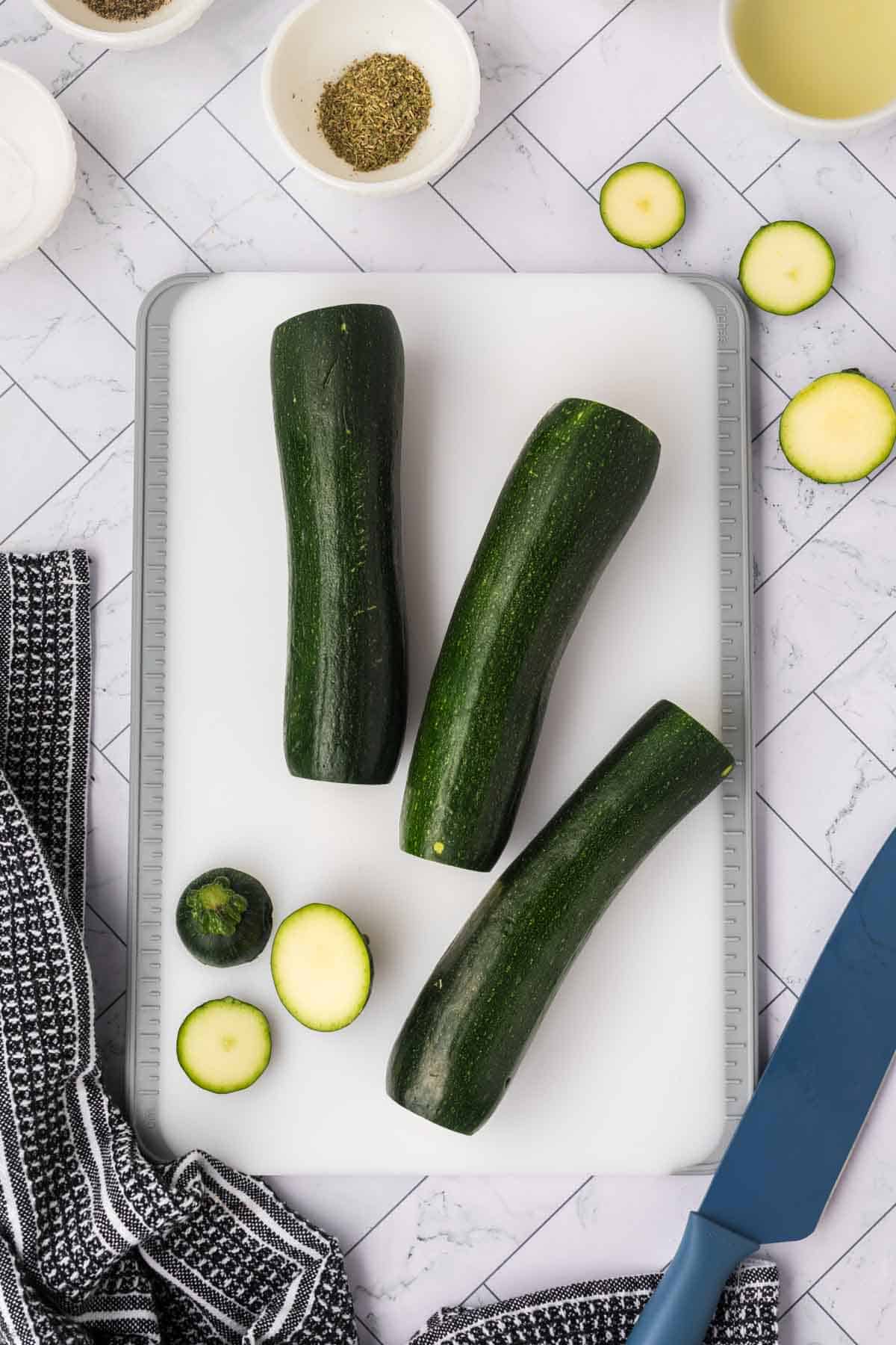 Zucchini on a cutting board with the ends cut off