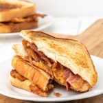 SM bacon sandwich served on a white plate.