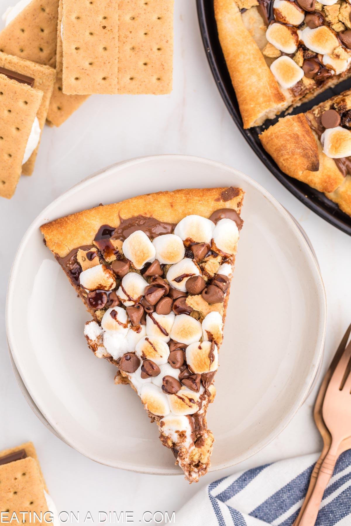 Close up image of slice of smores pizza on a white plate
