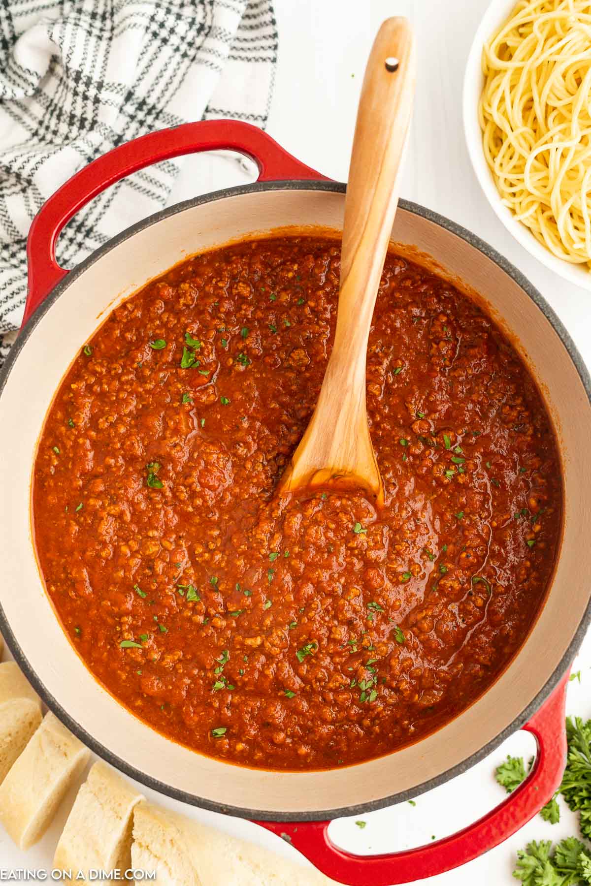 Bolognese Sauce in a Dutch Oven with a wooden spoon