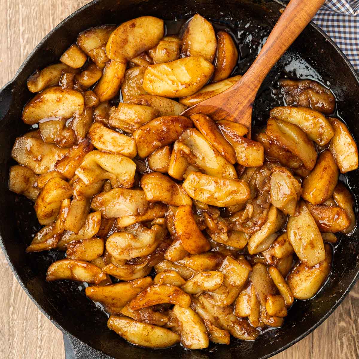 Fried Apples in a dish with a wooden spoon