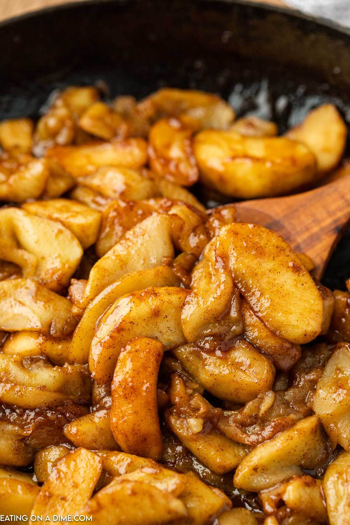 Fried Apples in a dish with a wooden spoon