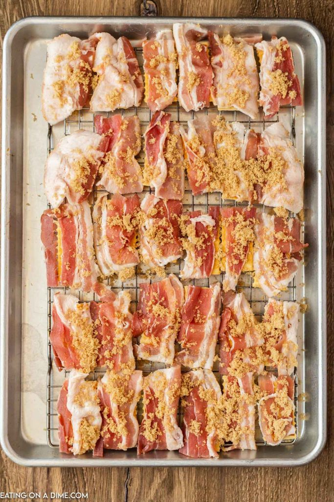 Bacon topped with brown sugar on baking sheet. 