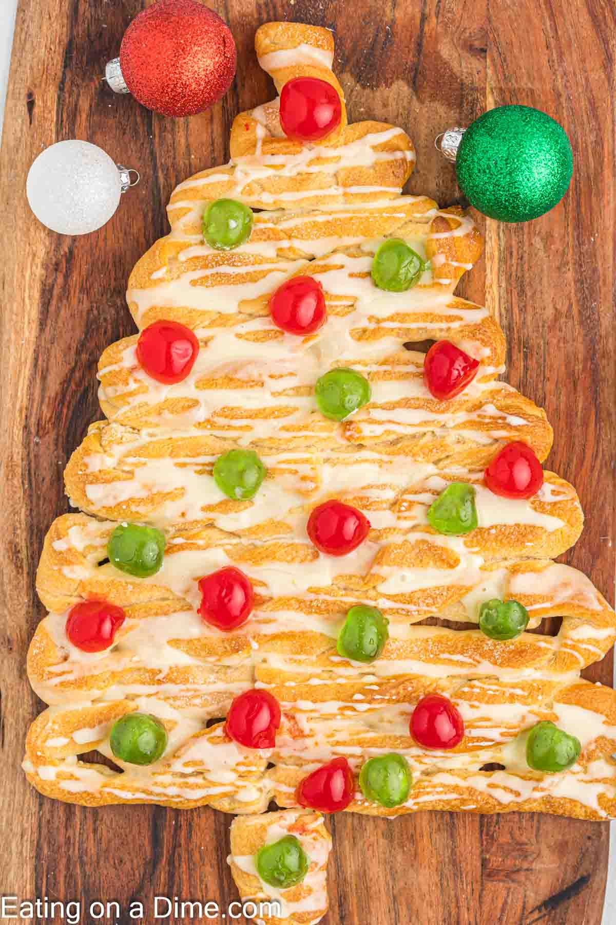 Christmas tree coffee cake topped with glaze and fruit. 