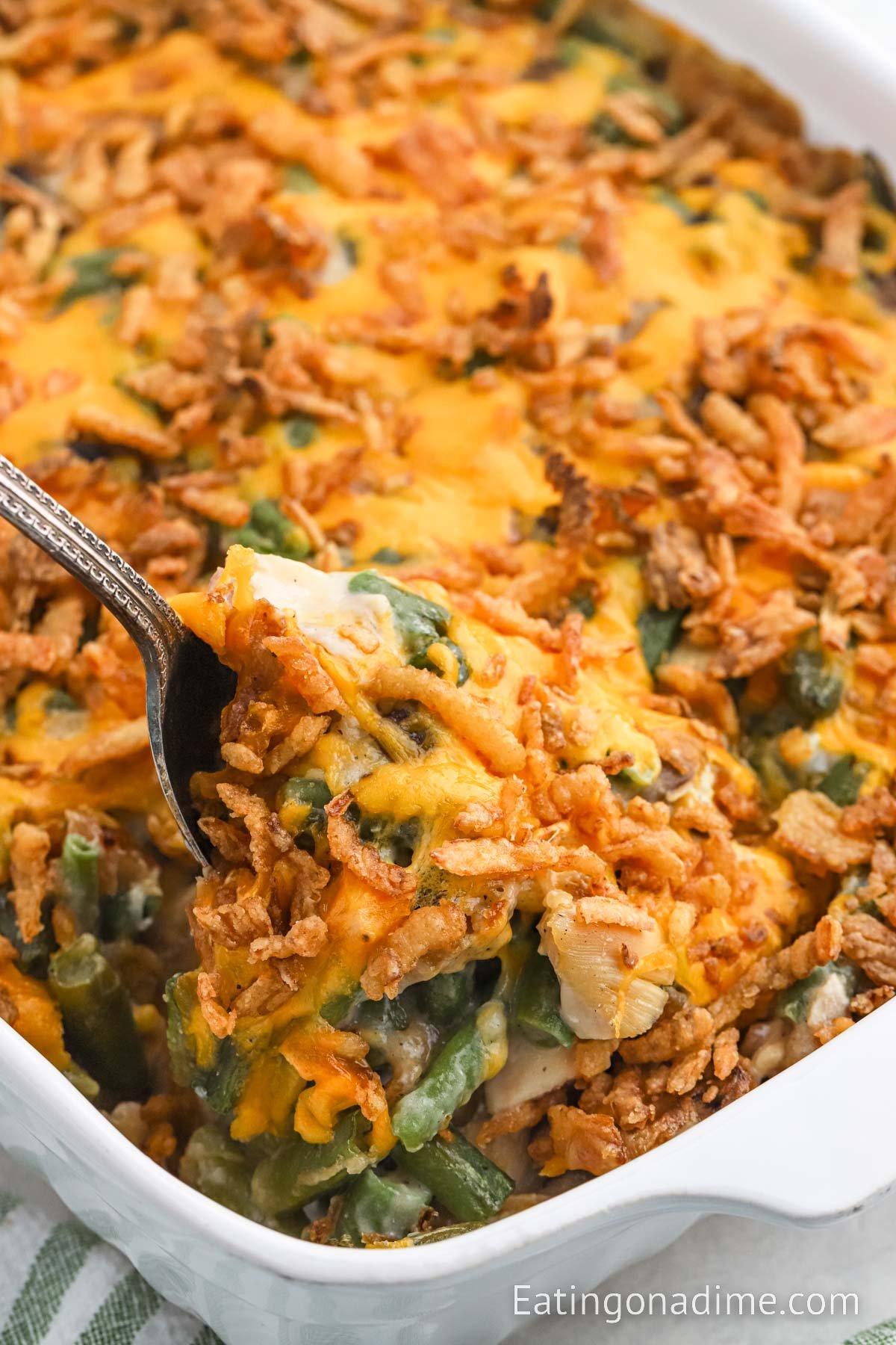 Chicken green bean casserole in a baking dish with a serving on a spoon