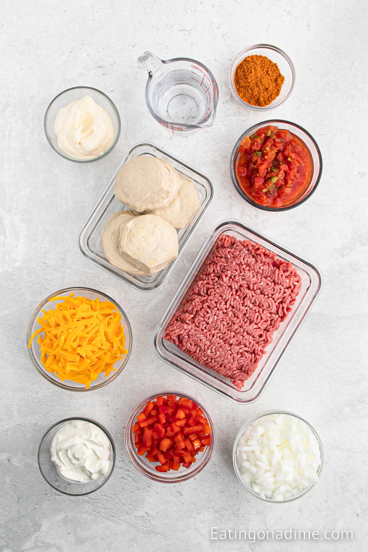 Ingredients needed for John Wayne casserole - Biscuits, beef, taco seasoning, water, onion, bell pepper, diced tomatoes, sour cream, mayonnaise, cheese