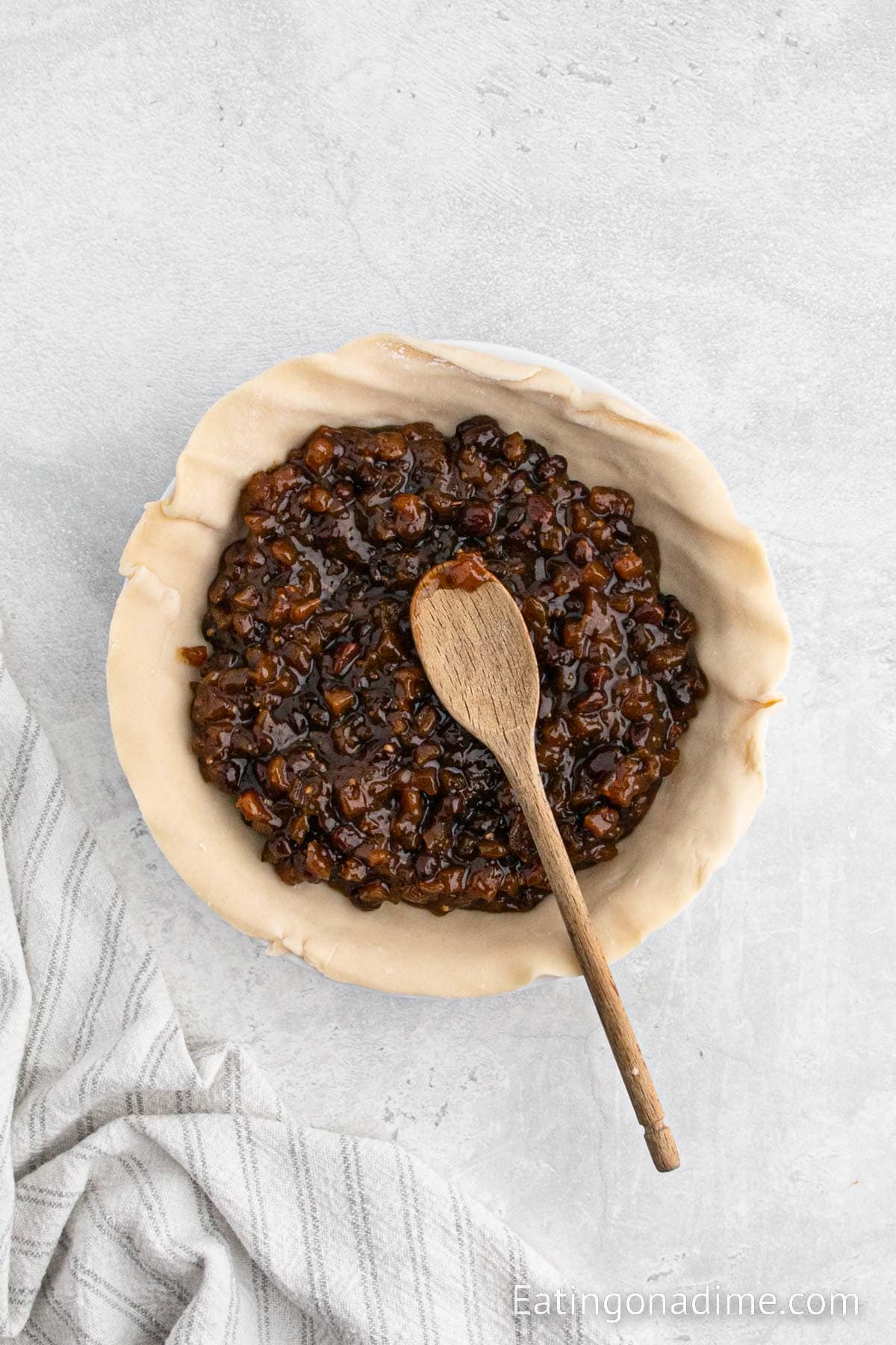 Spreading the mincemeat pie filling into crust