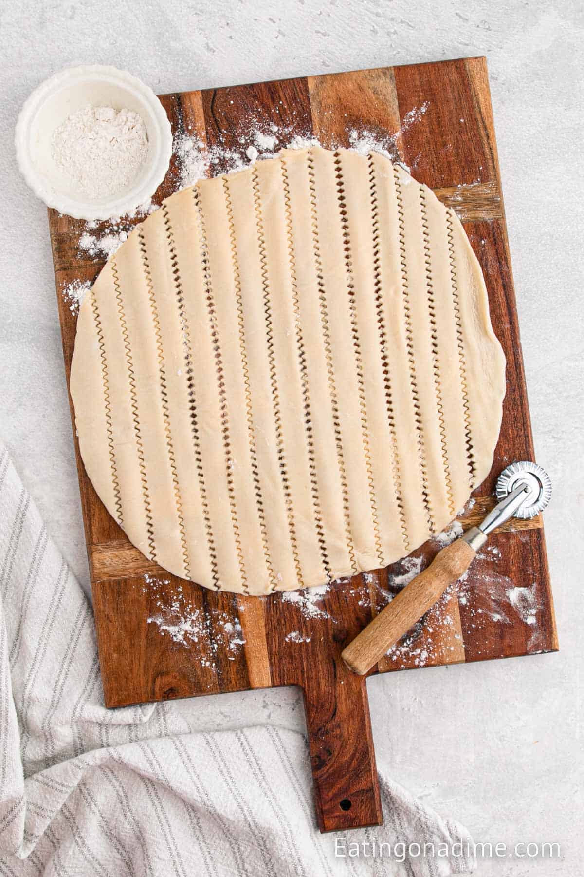 Cutting other pie crust into strips on a cutting board