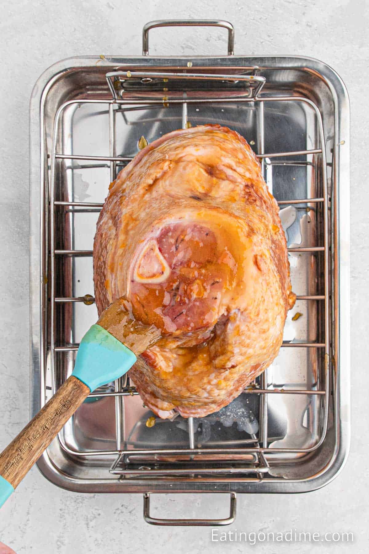 Basting ham with brush while in the roasting pan