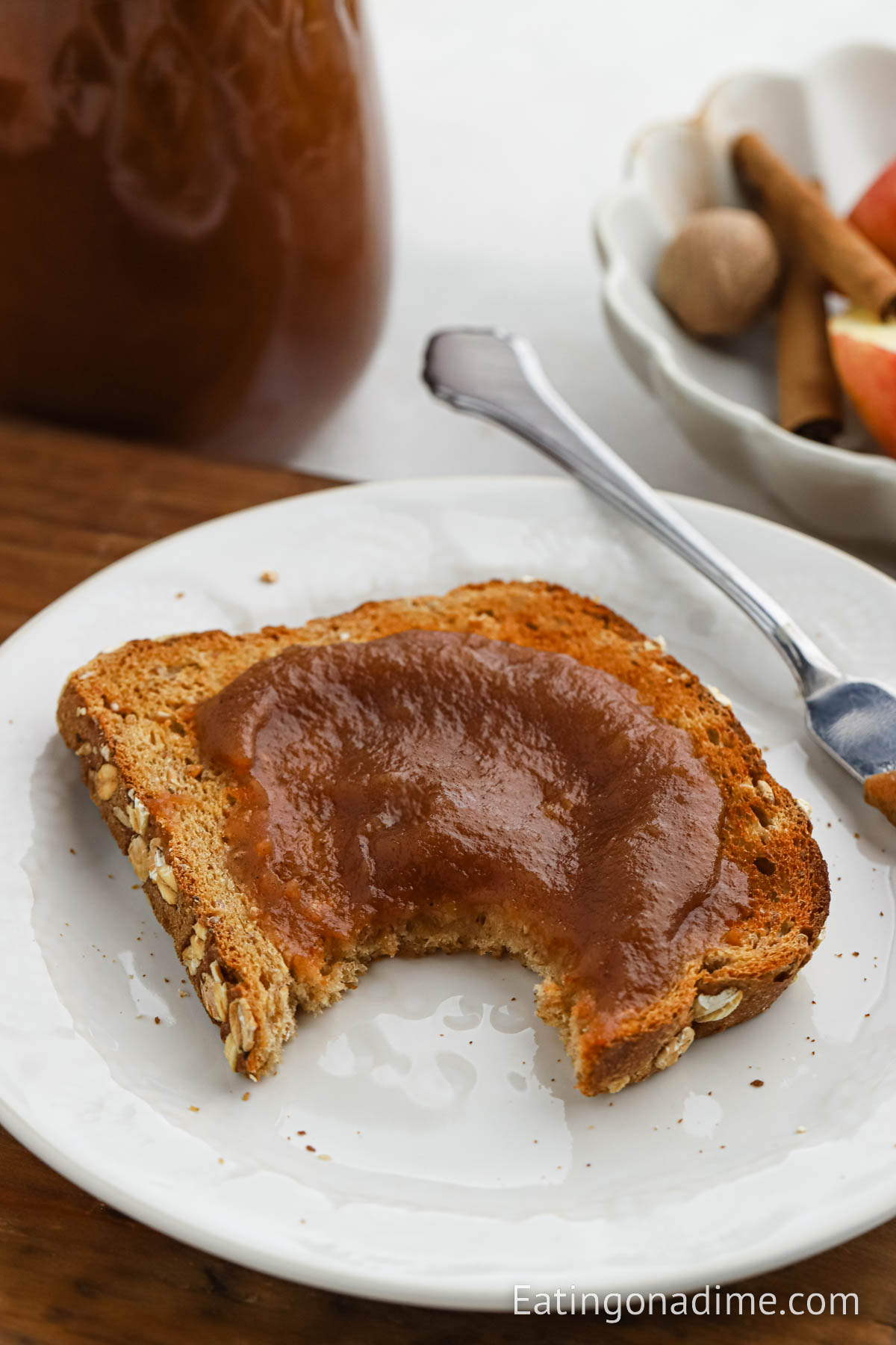 Apple butter spread on a piece of toast on white plate