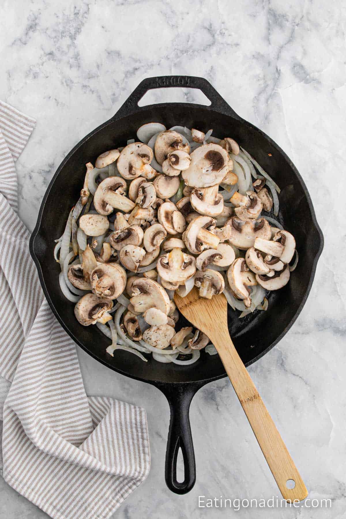 Adding in slice mushrooms to the skillet