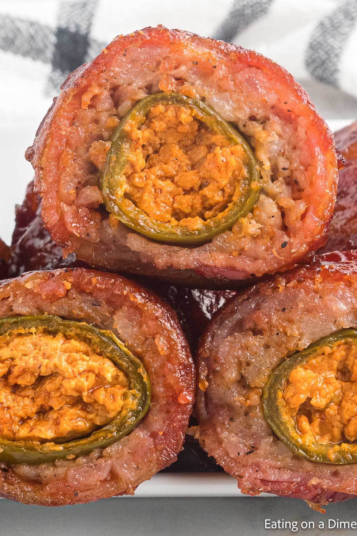 Armadillo Eggs cut in half and stacked on a plate