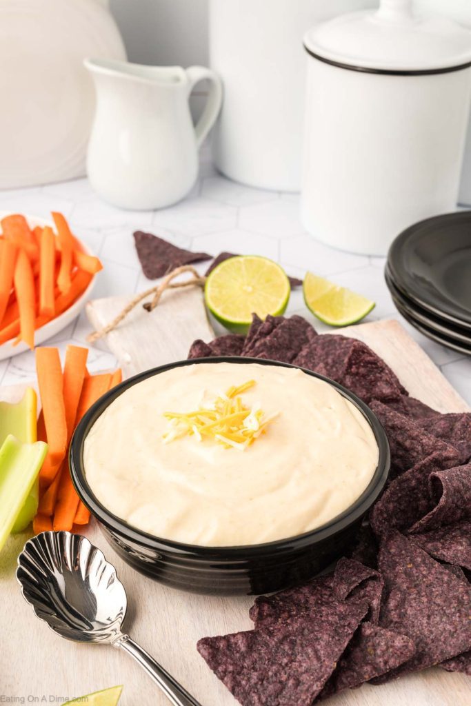 Cottage cheese queso on a plate with chips and raw veggies