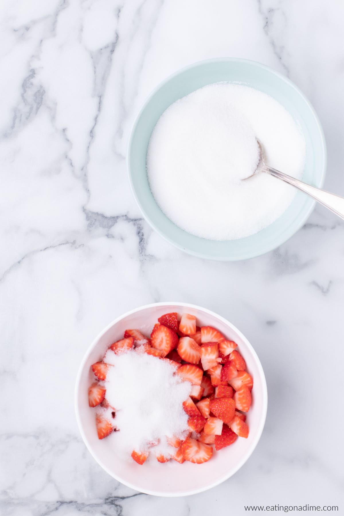 Strawberries in a bowl topped with sugar.