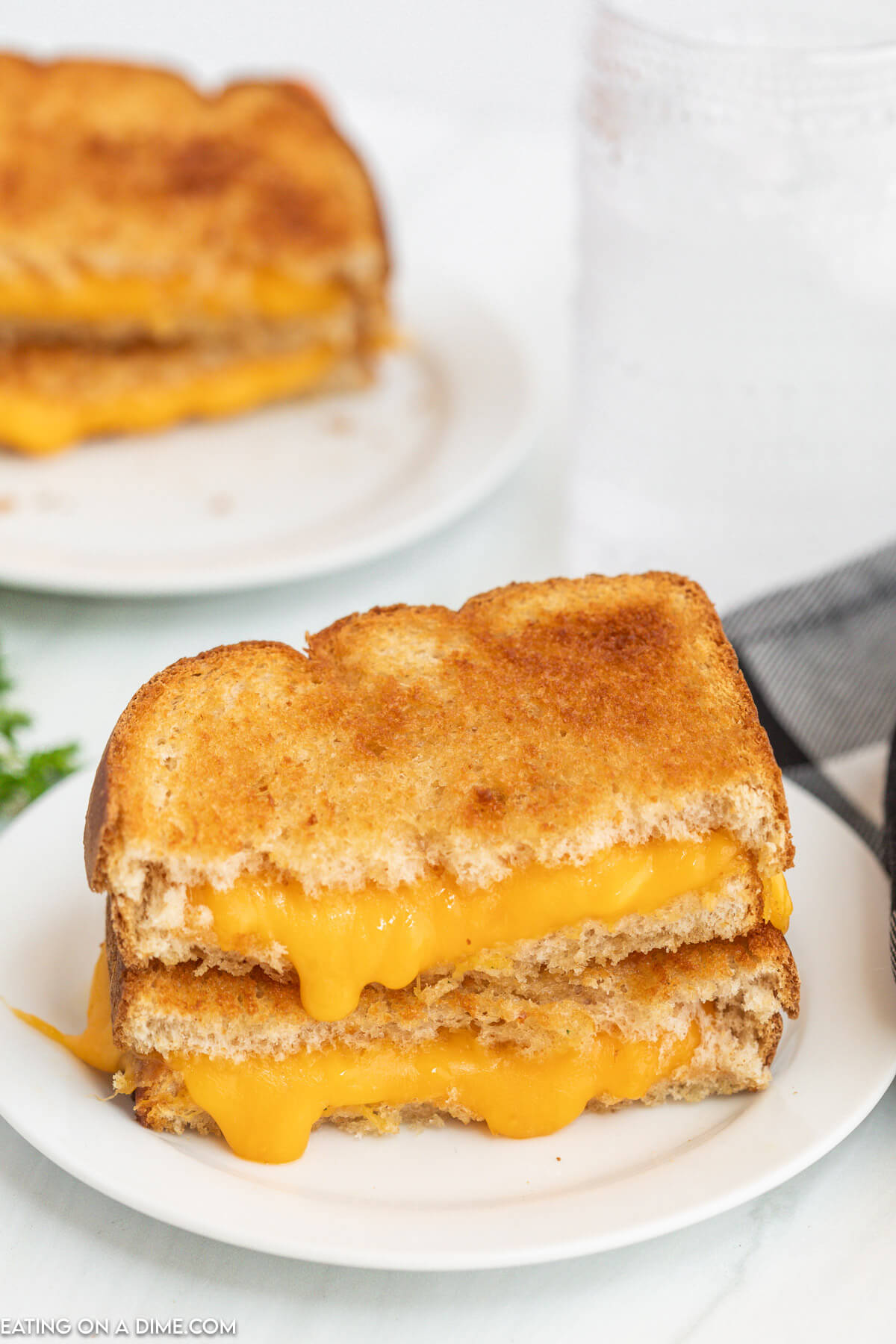 Grilled Cheese cut in half stacked on a plate